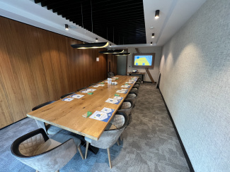 A seminar room with a long table and screen.