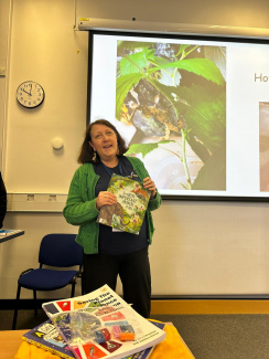 A teacher presenting photos from a nature project on a screen